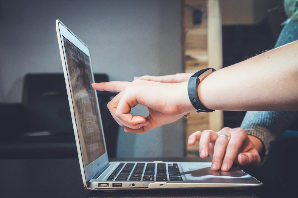 Digital content collaborators reviewing platform storytelling and online engagement on a laptop